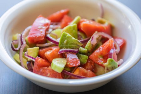 Deliciosa ensalada de verano con tomates, pepinos, cebolla roja y aguacate