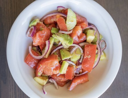 Delicious Summer Salad with Tomatoes, Cucumbers, Red Onion, and Avocado Close Up
