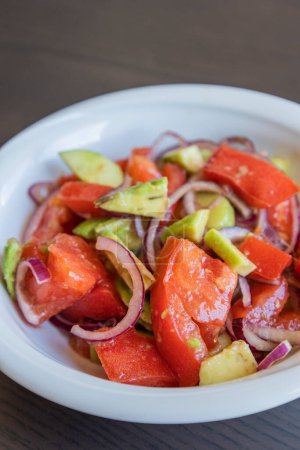 Delicious Summer Salad with Tomatoes, Cucumbers, Red Onion, and Avocado Close Up