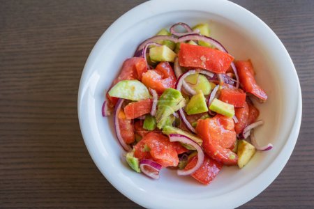 Deliciosa ensalada de verano con tomates, pepinos, cebolla roja y aguacate