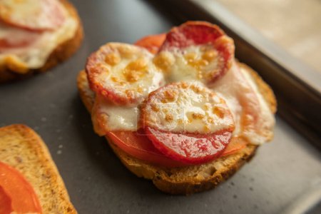 Delicioso brindis con tomate, salami y queso de cerca