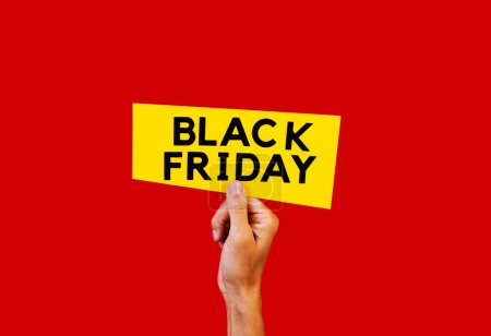 Photo for A man has a yellow sign in his hand with the text black friday, on a red background - Royalty Free Image