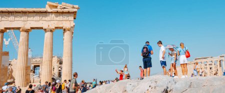 Photo for Athens, Greece - August 30, 2022: A crowd of tourists visit the Acropolis of Athens, in Greece, nenxt to the remains of the famous Parthenon, in a panoramic format - Royalty Free Image