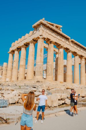 Foto de Atenas, Grecia - 30 de agosto de 2022: Algunas personas se toman fotos frente a los restos del famoso Partenón, en la Acrópolis de Atenas, Grecia - Imagen libre de derechos
