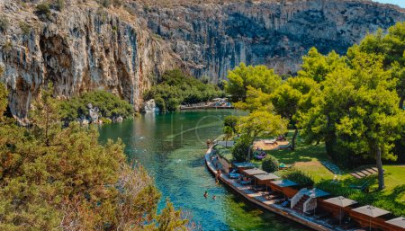 Téléchargez les photos : Vouliagmeni, Grèce - 1er septembre 2022 : Une vue sur le lac Vouliagmeni à Vouliagmeni, Grèce, avec beaucoup de gens profitant du beau temps d'une journée d'été - en image libre de droit