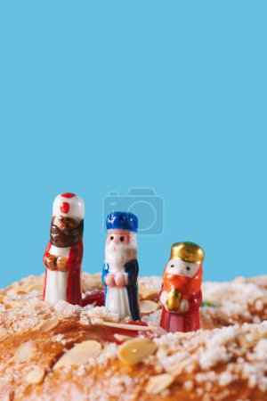 Foto de Primer plano de un roscon de reyes, el pastel español de tres reyes comido tradicionalmente en el día de la epifanía, y los tres reyes, melchior, caspar y balthazar, en la parte superior - Imagen libre de derechos