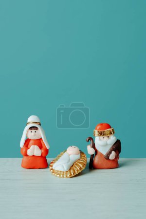 Photo for A depiction of the holy family, the virgin mary, the child jesus, and saint joseph, on a white surface, against a blue background with a blank space on top - Royalty Free Image