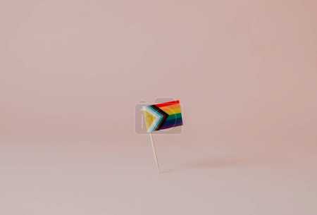 Téléchargez les photos : Un drapeau de fierté de progrès intersexué attaché à un poteau en bois debout sur un fond brun pâle ou rose - en image libre de droit