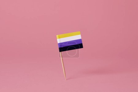 Téléchargez les photos : Un drapeau de fierté non binaire attaché à un poteau en bois se dresse sur un fond rose, - en image libre de droit