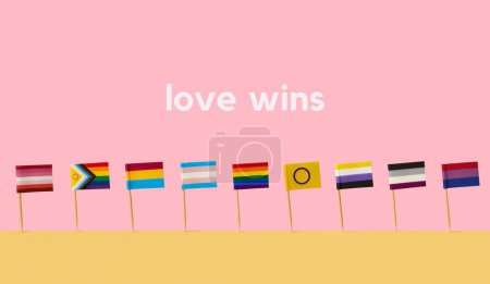 Foto de Diferentes banderas LGBTIQA unidas a postes de madera de pie lado a lado sobre una superficie amarilla, sobre un fondo rosa, y el amor texto gana - Imagen libre de derechos