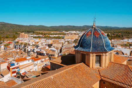 Foto de Una vista de pájaro de Alcalá de Xivert, en la Comunidad Valenciana, España, destacando la cúpula de la Iglesia de San Juan Bautista, cubierta con azulejos de cerámica azul - Imagen libre de derechos