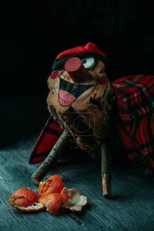 Photo for Closeup of a homemade tio de nadal, a magical christmas character, typical of catalonia, spain, feed by children with mandarin oranges, on a rustic wooden surface - Royalty Free Image