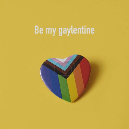 Photo for A heart-shaped progress pride flag and the text be my gaylentine on an orangish yellow background - Royalty Free Image