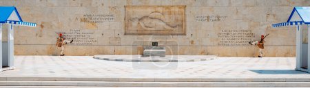 Foto de Athens, Greece - August 30, 2022: The changing of the guard at the Tomb of the Unknown Soldier in Athens, Greece, with the white and blue sentry boxes on each side, in a panoramic format - Imagen libre de derechos