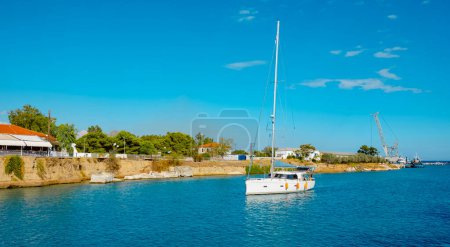 Téléchargez les photos : A sailboat at the entrance to the Corinth Canal, in Greece, from Isthnmia, in the Aegean sea, on a summer day - en image libre de droit
