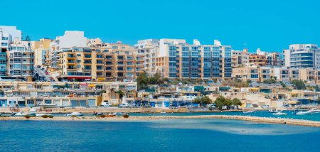 Téléchargez les photos : St Pauls Bay, Malta - September 5, 2022: A panoramic view of Qawra, in St Pauls Bay, Malta, on its coastline surrounding Salina Bay - en image libre de droit