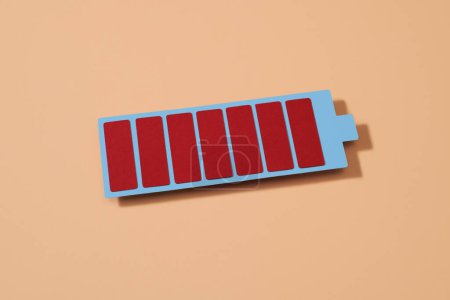 Foto de Una representación de cartón de una batería completamente cargada sobre un fondo rosa pálido - Imagen libre de derechos