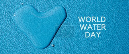 Téléchargez les photos : Une goutte d'eau en forme de cœur et le texte journée mondiale de l'eau sur une surface texturée bleue, dans un format panoramique à utiliser comme bannière Web ou en-tête - en image libre de droit