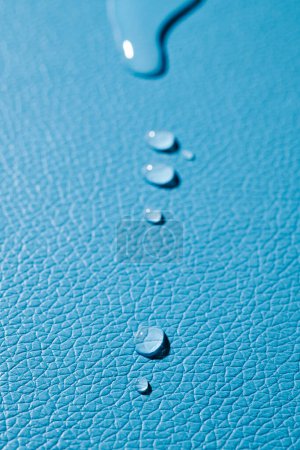 Foto de Primer plano de algunas gotas de agua sobre una superficie de cuero azul - Imagen libre de derechos