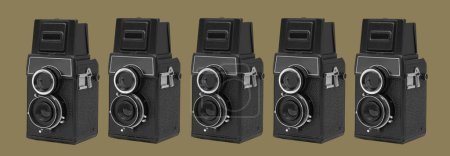 Téléchargez les photos : Certaines caméras de cinéma rétro noir moyen format sur fond vert olive dans un format panoramique à utiliser comme bannière web ou en-tête - en image libre de droit