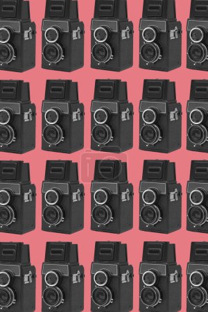 Foto de Algunas cámaras de cine de formato medio retro negro dispuestas en diferentes líneas formando un fondo rosa mosaico - Imagen libre de derechos