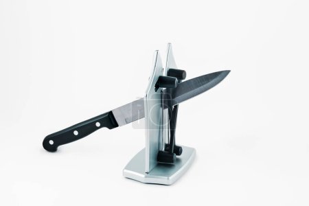 Téléchargez les photos : Un couteau de cuisine dans un taille-couteau de bureau, sur fond blanc - en image libre de droit