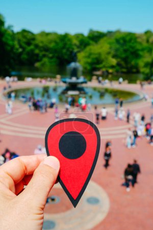 Photo for The hand of a man holds a red marker pointing Bethesda Terrace in Central Park, New York City, United States, on a sunny spring day - Royalty Free Image