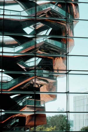 Foto de Nueva York, Estados Unidos - 19 de mayo de 2023: La estructura del buque se refleja en la superficie exterior de vidrio de las tiendas y restaurantes en el centro comercial Hudson Yards, en la ciudad de Nueva York, Estados Unidos, en un día de primavera - Imagen libre de derechos