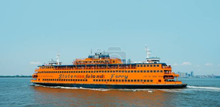 Photo for New York City, United States - May 22, 2023: A ferryboat of the Staten Island Ferry browses by the New York Bay, United States, on a sunny spring day - Royalty Free Image
