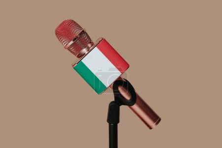 Foto de Primer plano de un micrófono modelado con la bandera italiana colocada en un soporte negro sobre un fondo marrón - Imagen libre de derechos