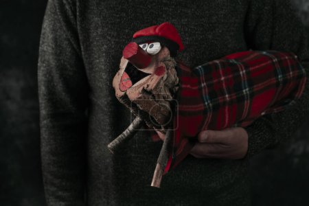 Photo for Closeup of a man carrying a homemade catalan tio de nadal, a magical christmas character, typical of Catalonia, Spain, wearing a barretina, a typical Catalan red cap - Royalty Free Image