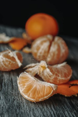 Téléchargez les photos : Quelques oranges de mandarine pelées sur une table en bois rustique gris - en image libre de droit