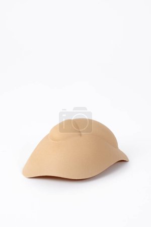Photo for A beige textile male genitalia padding on a white background with some blank space on top - Royalty Free Image