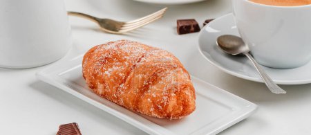 Photo for A xuixo de crema, a pastry filled with custard typical of catalonia, spain, on a rectangular plate on a table, in a panoramic format to use as web banner - Royalty Free Image