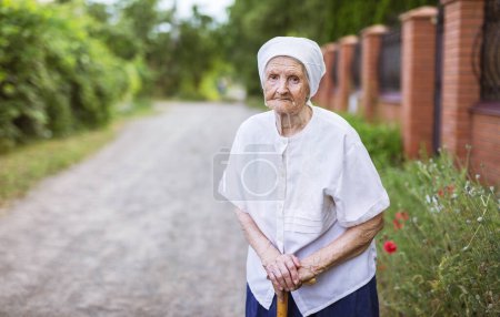 Photo for Portrait of senior woman outdoors. Aged Caucasian woman standing near fence in village. - Royalty Free Image