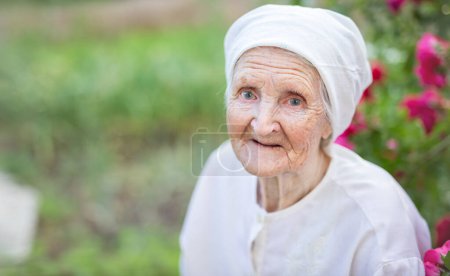 Photo for Portrait of senior woman outdoors. Aged lady looking up at camera and smiling. - Royalty Free Image