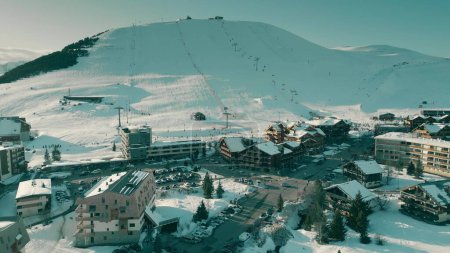 Aerial drone shot of hotels and Alpine ski track