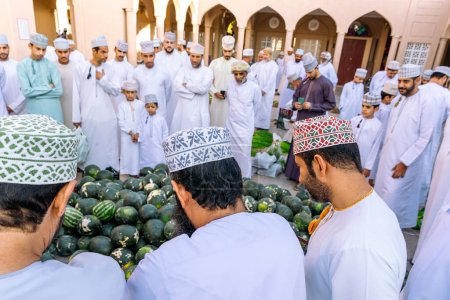 Téléchargez les photos : NIZWA, OMAN - 18 NOVEMBRE 2022 : Nizwa Goat Market. Les gens qui vendent des fruits frais.Bazar traditionnel de fruits et légumes à Nizwa, Oman. - en image libre de droit