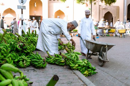 Foto de NIZWA, OMAN - 18 de noviembre de 2022: Nizwa Goat Market. Gente vendiendo frutas frescas.Bazar de frutas y verduras tradicionales en Nizwa, Omán. - Imagen libre de derechos