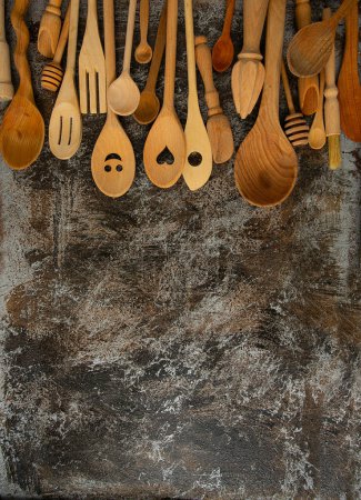 Foto de Hermosas cucharas de madera y utensilios en la superficie de piedra, vista superior - Imagen libre de derechos