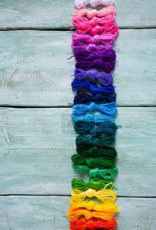 Foto de Conjunto de hilos multicolores para bordar en bacground de madera turquesa - Imagen libre de derechos