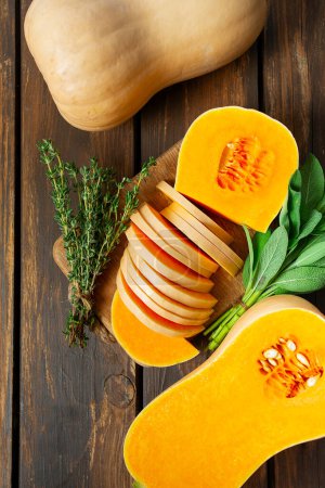 Photo for Fresh butternut squash with thyme and sage on a wooden surface.  Butternut Pumpkin . Healthy food concept. - Royalty Free Image