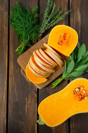 Photo for Fresh butternut squash with thyme and sage on a wooden surface.  Butternut Pumpkin . Healthy food concept. TOP VIEW. - Royalty Free Image