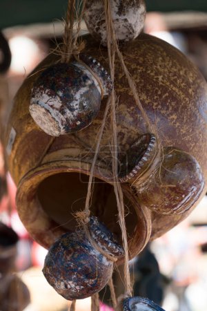 Foto de Sol destaca en un paquete de jarras de cerámica amarilla colgadas de cuerdas en taller de cerámica en Old Town, San Diego, California - Imagen libre de derechos
