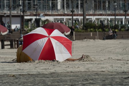 Foto de Lea y los colores blancos en un paraguas de playa protegiendo a la familia en la playa de Coronado, San Diego - Imagen libre de derechos