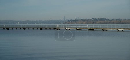 Looking at Juanita  Beach Pier with Seattle downtown in the background right after sunrise on a sunny morning in March