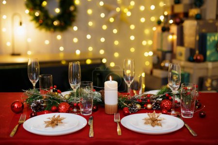 Photo for Table with plates and champagne glasses for christmas dinner. Garland on background - Royalty Free Image