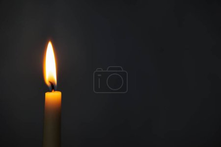 Photo for Close up of burning yellow candle over dark background with copy space - Royalty Free Image