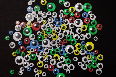 Photo for Various sizes and color of funny kids art googly eyes on black background - Royalty Free Image