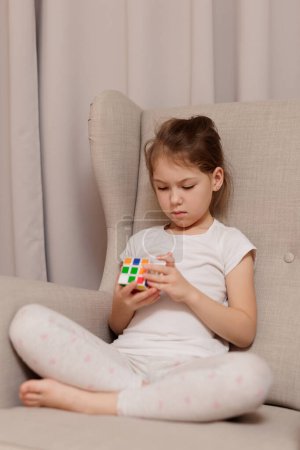 Photo for Portrait of little cute girl holding Rubik's cube in her hands - Royalty Free Image